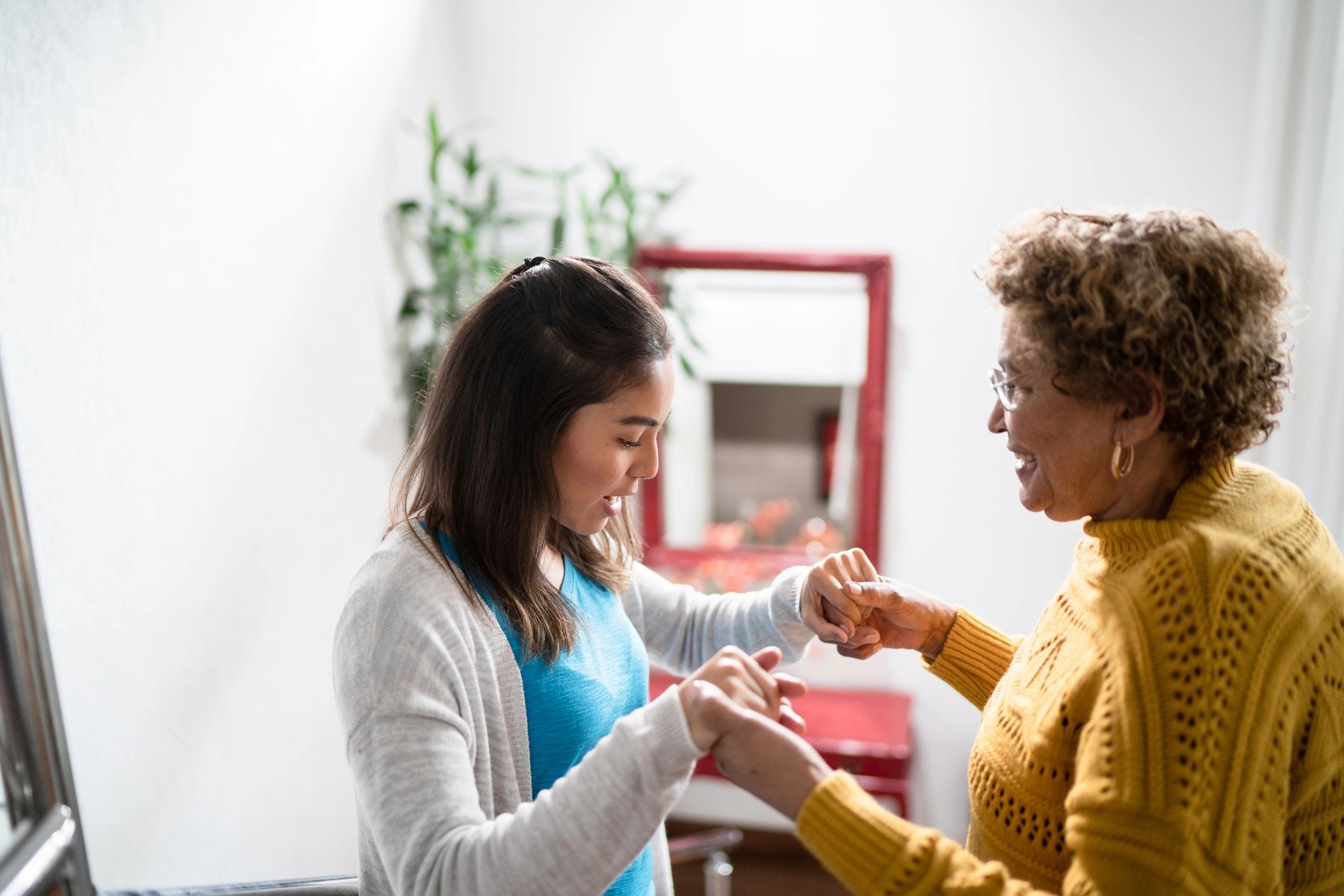 Therapist supporting a senior client with mobility at home